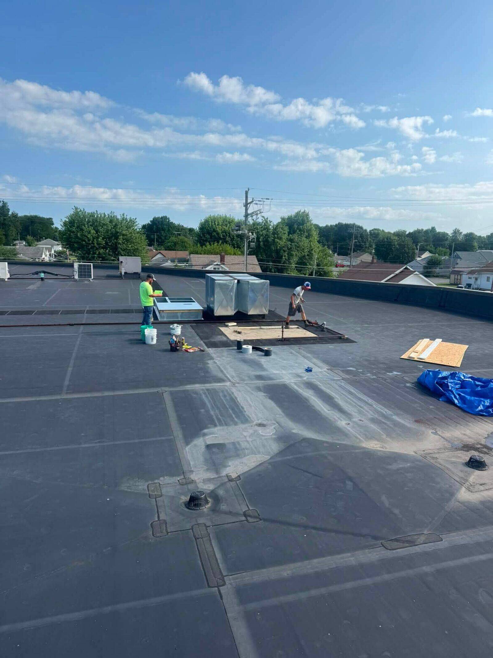 Crew working on a large flat roof mid-installation.