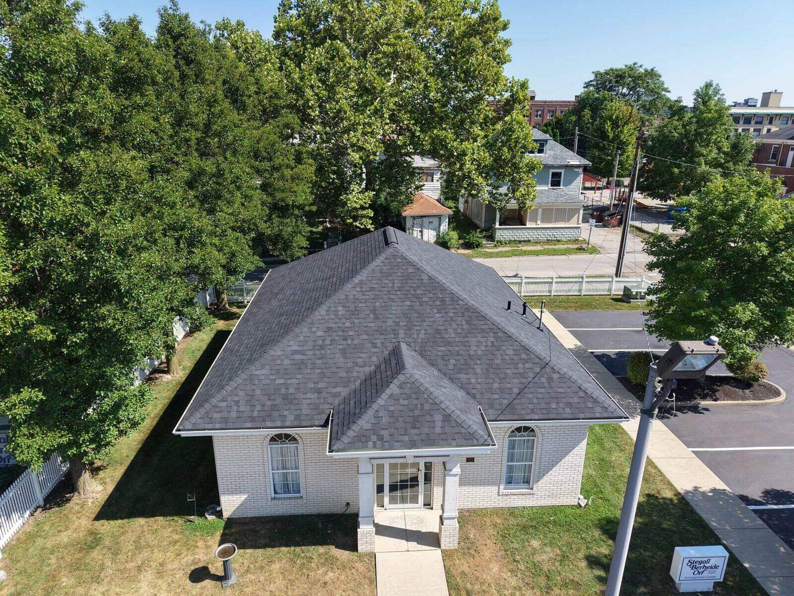 Aerial view of a house with a newly completed roof, a Chomel and Sons job.